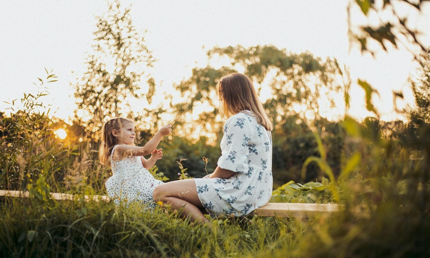 Mutter und kleines Mädchen im sommerlichen Garten – Aktivitäten für Kinder in den Sommerferien