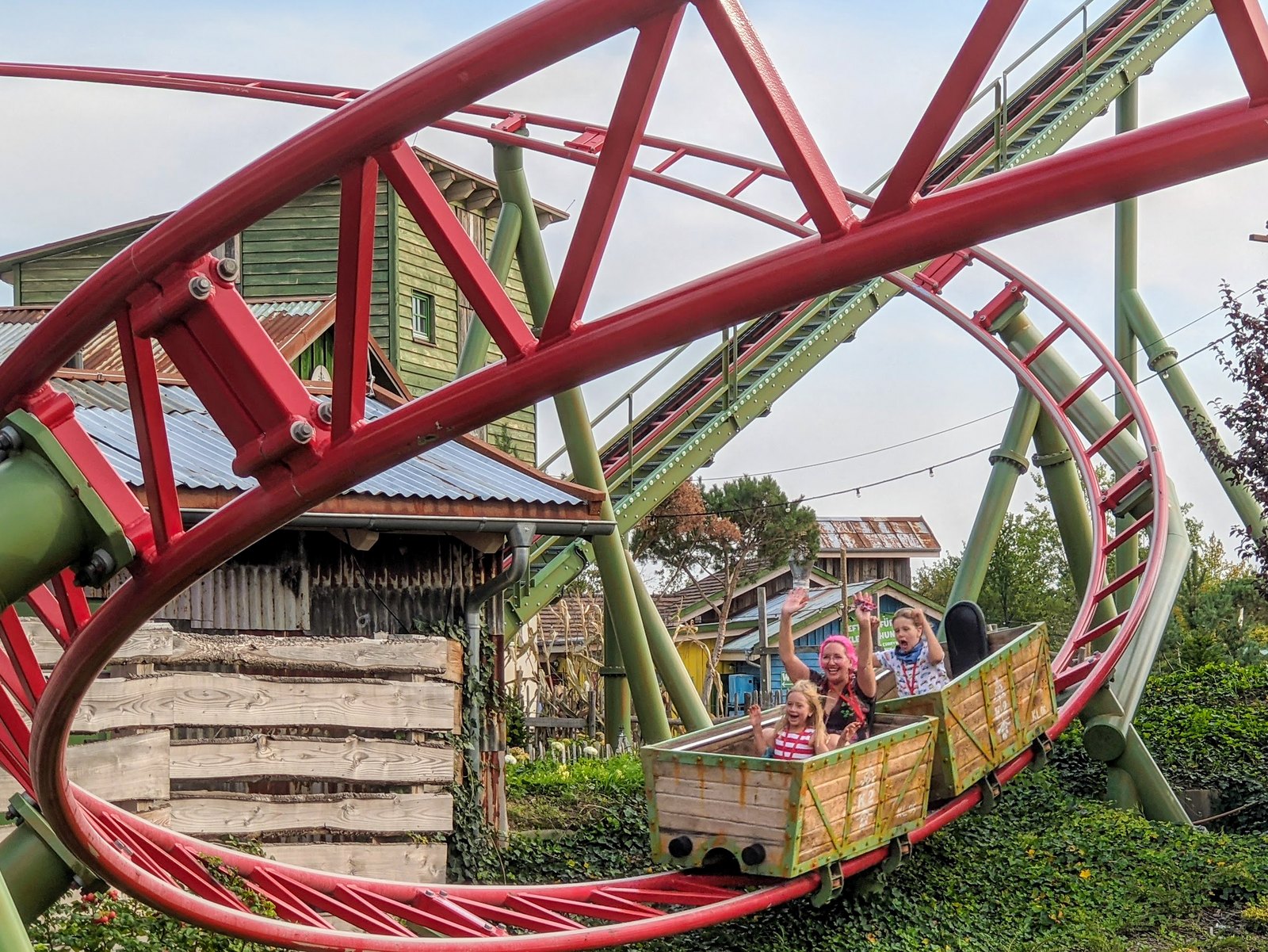 Wagen der K2-Achterbahn bei Karls in Elstal, Mitfahrende winken aus dem Holzwagen